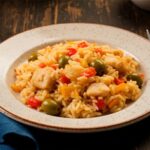 Arroz de bacalhau servido em um prato na mesa.
