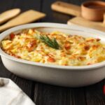 Escondidinho de bacalhau dentro de uma travessa na mesa.