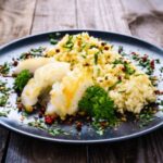 risoto de bacalhau em um prato preto