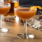 Taça de blood and sand na mesa com laranja