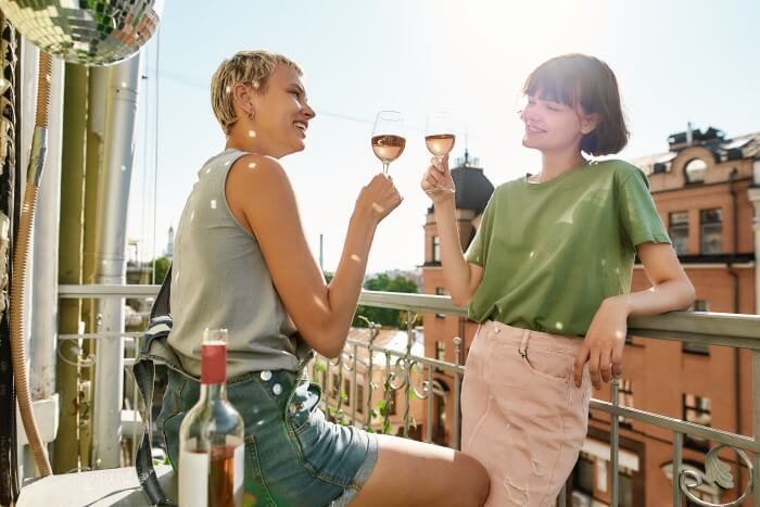 duas mulheres apreciando vinho rosé