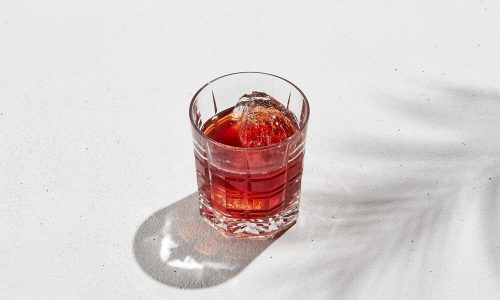 Foto De Um Copo Com Um Drink Com Campari Sob Um Fundo Branco.