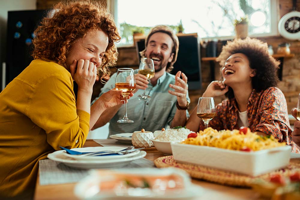 Duas Mulheres E Um Homem Degustando Vinho No Almoço