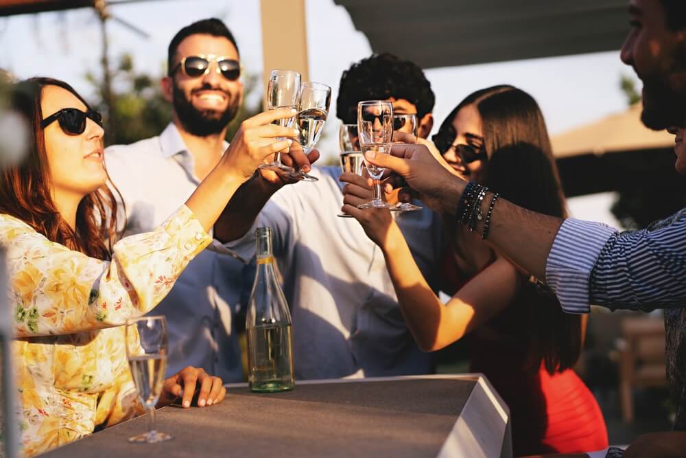 Imagem De Um Grupo De Homens E Mulheres Fazendo Um Brinde Enquanto Apreciam Um Prosecco.