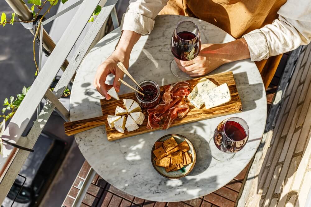 Imagem de uma mesa repleta de opções de queijos que harmonizam com vinho carménère.