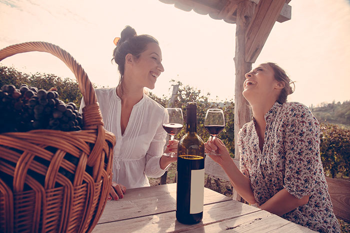 duas mulheres tomando vinho da uva cabernet sauvignon