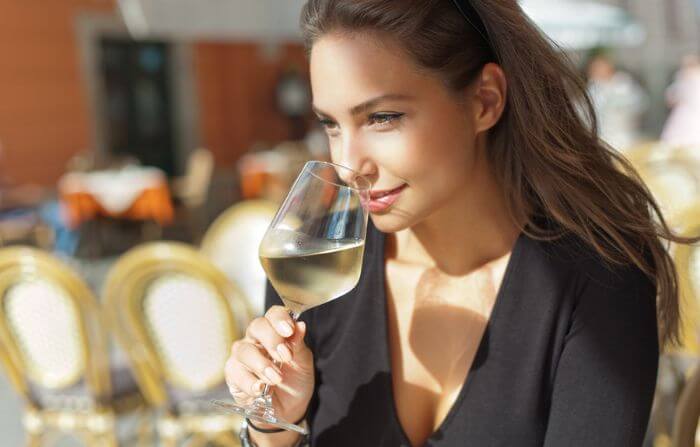 Mulher tomando vinho Sauvignon Blanc, um dos melhores vinhos para iniciantes