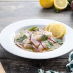 Prato de ceviche de tilápia com manga em cima de uma mesa.