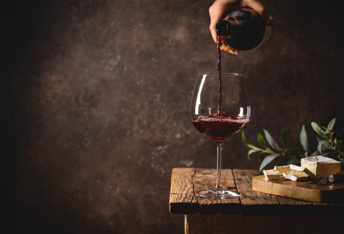 Vinho tinto sendo colocado na taça Borgonha.