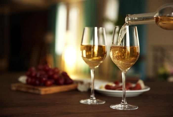 Vinho branco sendo colocado em taça.
