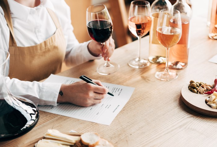 Sommelier segurando taça de vinho pela haste.