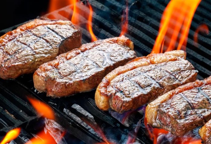 Peças de picanha assando em uma churrasqueira