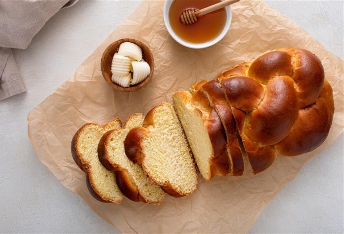 Pão bonito cortado em fatias com mel em um pote ao lado