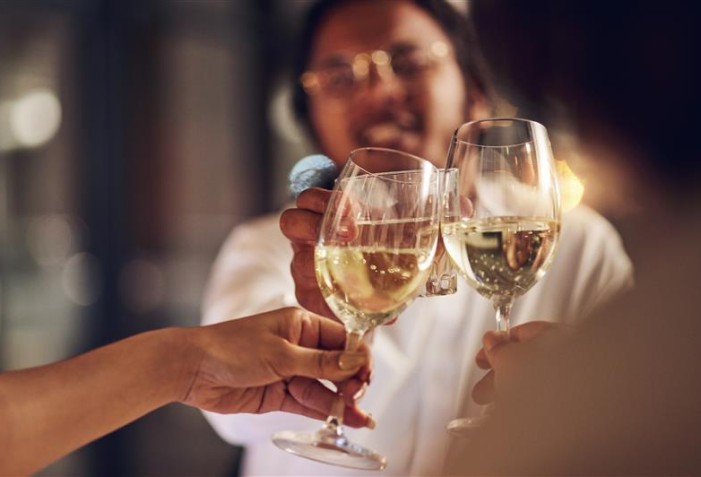 Pessoas brindando com vinho frisante.