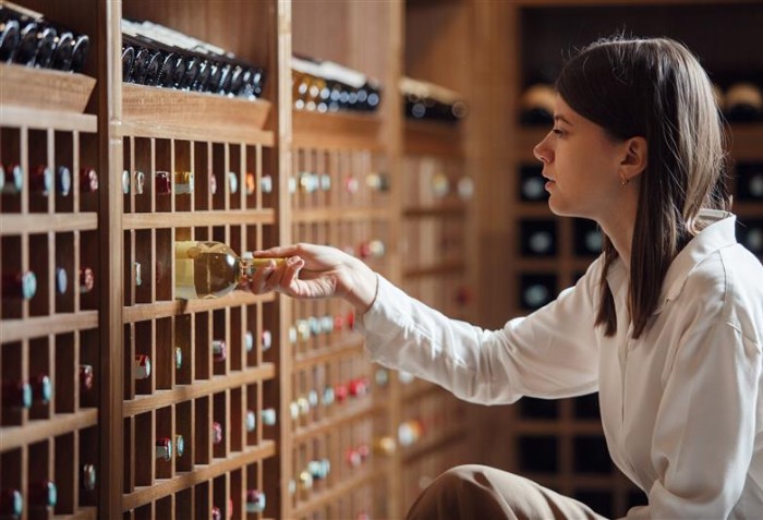 Uma mulher organizado vinhos em uma adega.