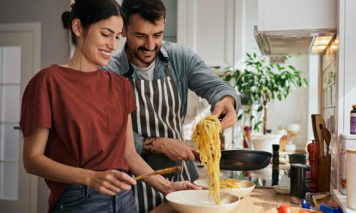 Um Casal Na Cozinha Preparando Macarrão