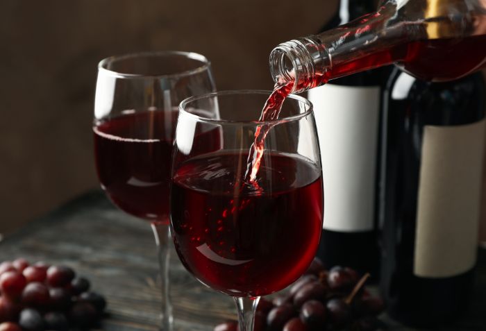 Vinho tinto sendo serviço em uma taça.