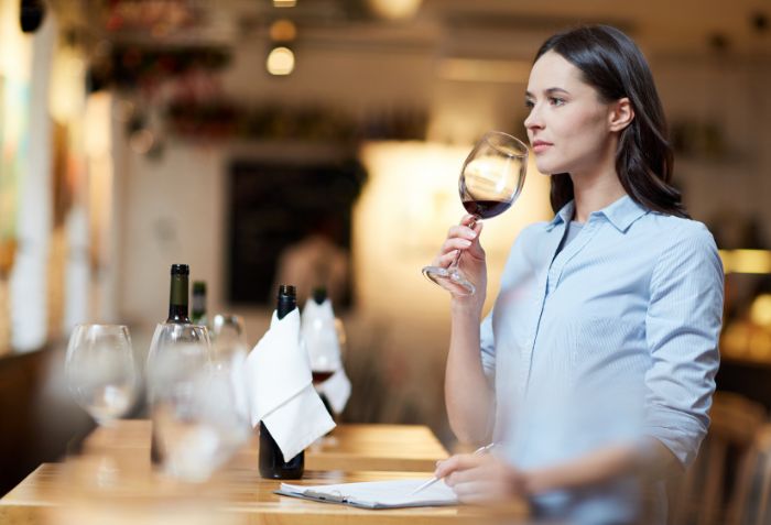 Mulher degustando e escolhendo vinhos