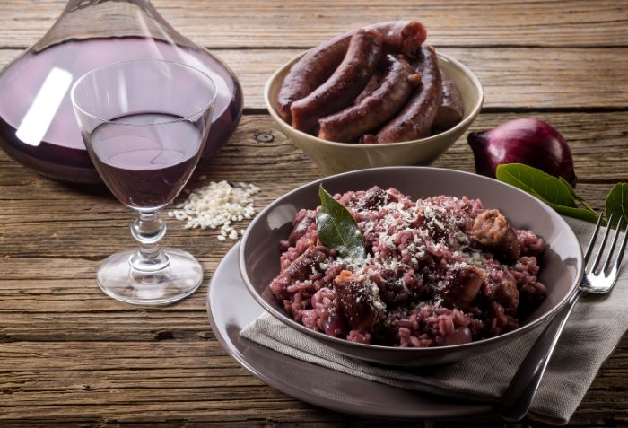 Prato de risoto preparado com linguiça e vinho tinto.